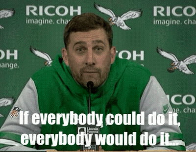 Man Speaking Into Microphone In Front Of Ricoh Sign GIF
