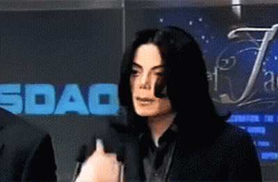 Man Speaking Into Microphone In Front Of Sdaq Sign GIF