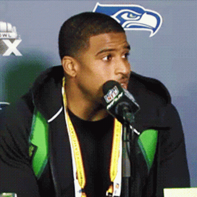 Man Speaking Into Microphone With Seahawks Logo GIF