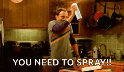 Man Spraying Something In Kitchen With Towel GIF