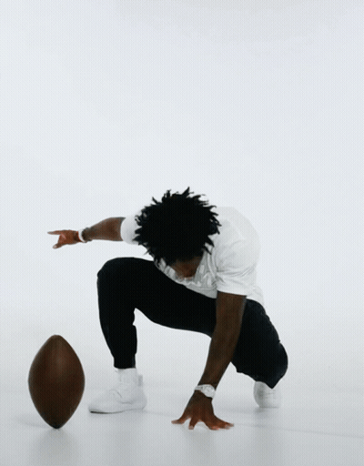 Man Squatting Holding Wilson Football GIF