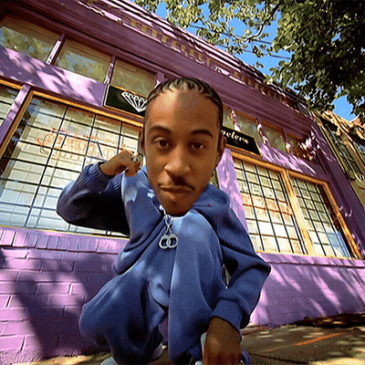 Man Squatting In Front Of Purple Building With Jewelers Sign GIF