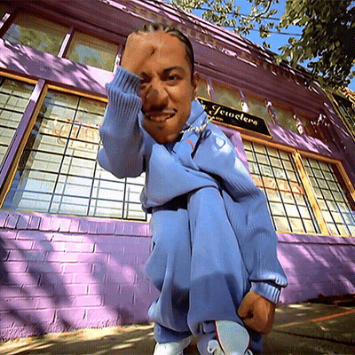 Man Squatting In Front Of Purple Jewelry Building GIF