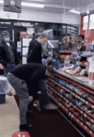 Man Squatting In Store With Exit Sign GIF