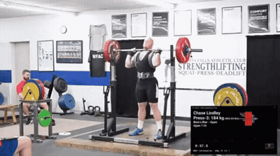 Man Squatting With Barbell In Front Of Strengthlifting Sign GIF