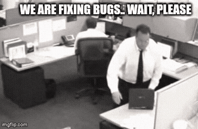 Man Standing At Desk With Laptop Sign Saying We Are Fixing Bugs Wait Please GIF