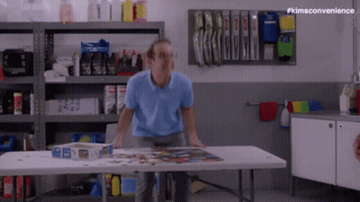 Man Standing At Table With Puzzle Box GIF