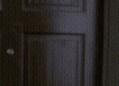 Man Standing At Window With Blinds GIF