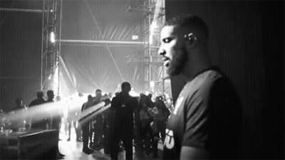 Man Standing Before Crowd In Black And White GIF