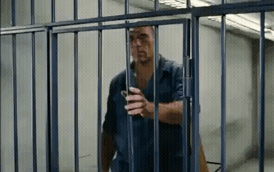 Man Standing Behind Bars In Jail Cell GIF