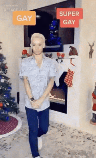 Man Standing By Fireplace And Christmas Tree GIF