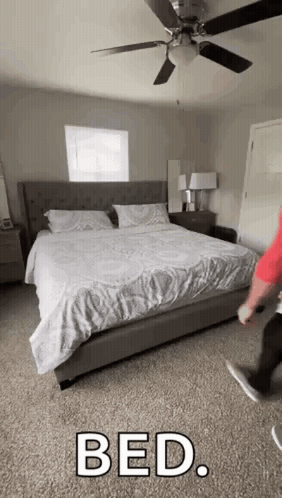 Man Standing In Bedroom Next To Bed GIF