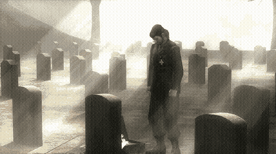Man Standing In Cemetery With Cross On Chest GIF