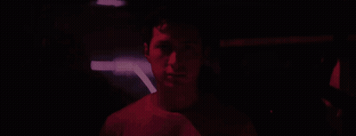 Man Standing In Crowd In Dark Room GIF
