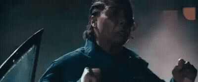 Man Standing In Dark Room With Hands In Air GIF