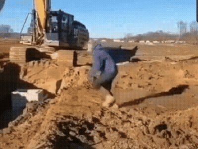 Man Standing In Dirt Front Of Excavator GIF