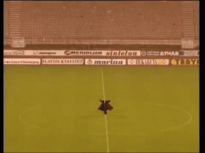 Man Standing In Empty Soccer Stadium With Ads GIF