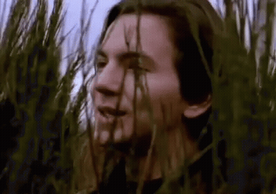 Man Standing In Field Of Tall Grass Looking At Camera GIF