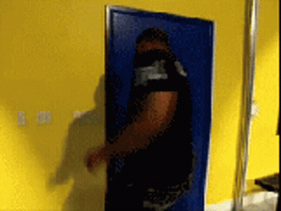 Man Standing In Front Of Blue Door With Yellow Wall GIF