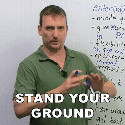 Man Standing In Front Of Board Saying Stand Your Ground GIF