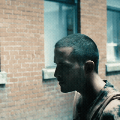 Man Standing In Front Of Brick Building GIF