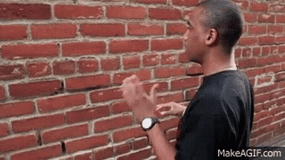 Man Standing In Front Of Brick Wall GIF