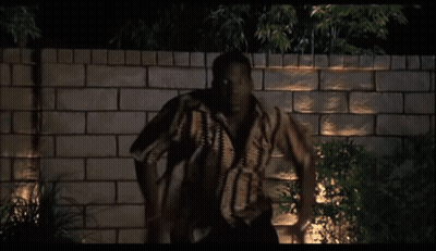 Man Standing In Front Of Brick Wall At Night GIF