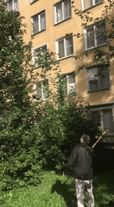 Man Standing In Front Of Building With Rake GIF