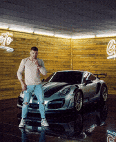 Man Standing in Front of Car with G Sign