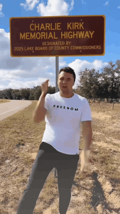 Man Standing In Front Of Charlie Kirk Memorial Highway GIF