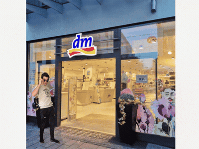 Man Standing In Front Of DM Store GIF