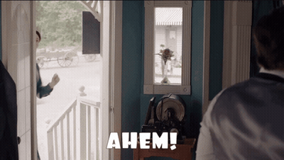 Man Standing in Front of Door Saying Ahem