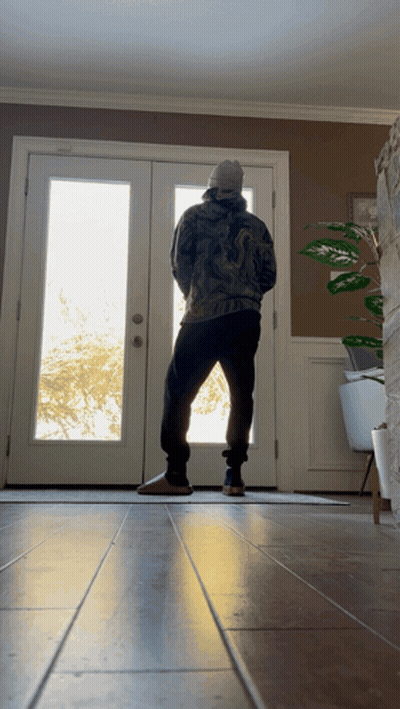 Man Standing In Front Of Door With Plant GIF