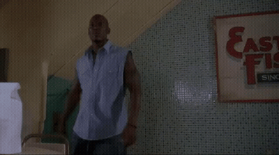 Man Standing In Front Of East Fish Sign GIF