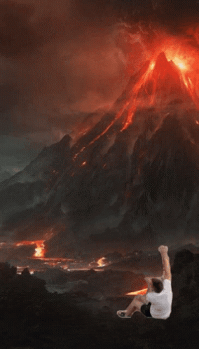 Man Standing In Front Of Erupting Volcano GIF