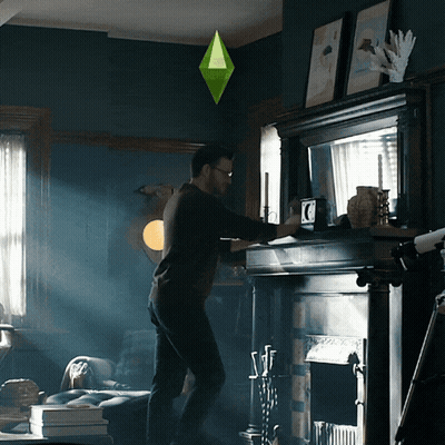 Man Standing In Front Of Fireplace With Green Diamond Hanging Above GIF