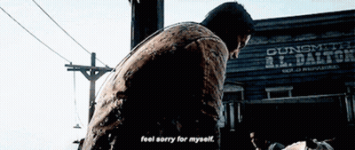 Man Standing In Front Of Gunsmith R.L. Dalton Building GIF