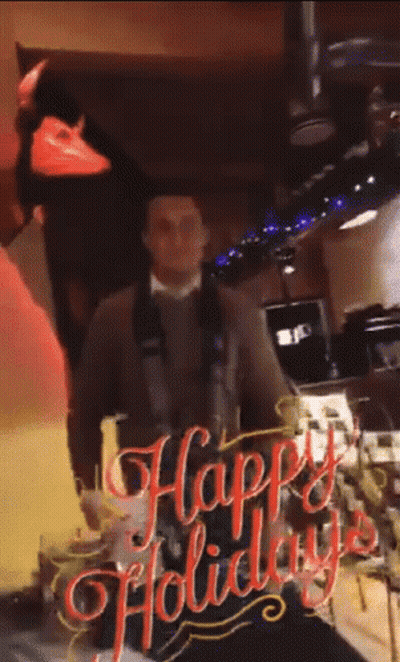 Man Standing In Front Of Happy Holiday Sign GIF