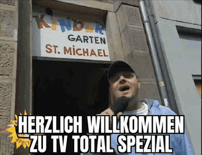 Man Standing In Front Of Kindergarten St. Michael Sign GIF
