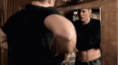 Man Standing In Front Of Mirror Looking At Himself GIF