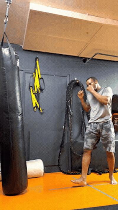 Man Standing In Front Of Punching Bag GIF