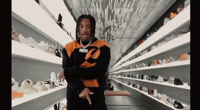 Man Standing In Front Of Shelf Full Of Shoes GIF