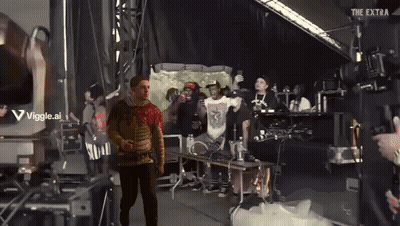 Man Standing In Front Of Stage With Viggle.ai Sign GIF