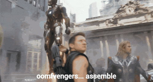 Man Standing In Front Of Statue Saying Assemble GIF