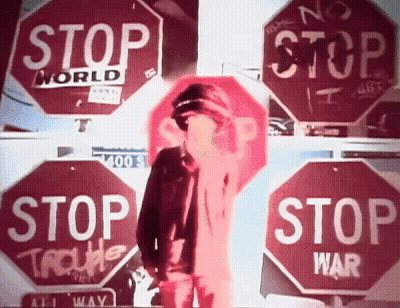 Man Standing In Front Of Stop Signs GIF
