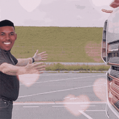 Man Standing In Front Of Truck With Arms Outstretched Smiling GIF