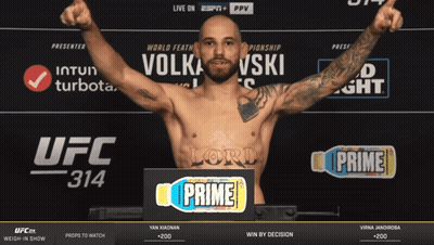 Man Standing In Front Of UFC 314 Sign GIF