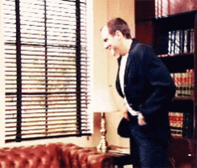 Man Standing In Front Of Window With Blinds GIF