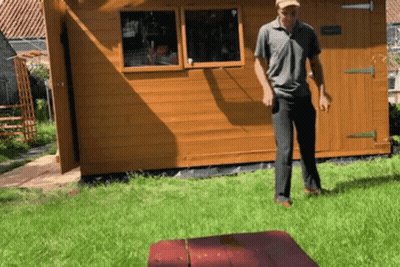 Man Standing In Front Of Wooden Shed GIF