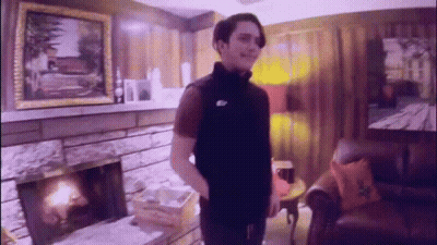 Man Standing In Living Room In Front Of Fireplace And Couch GIF